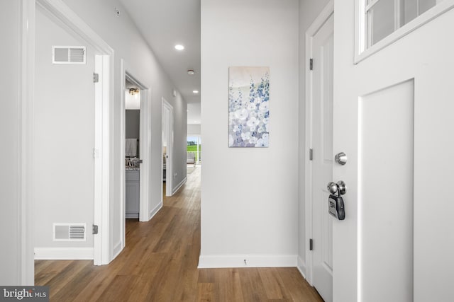 hall featuring recessed lighting, visible vents, baseboards, and wood finished floors