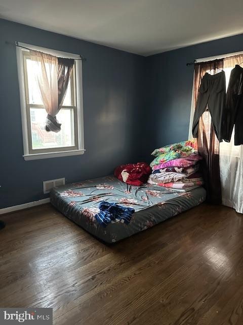 bedroom with dark hardwood / wood-style floors