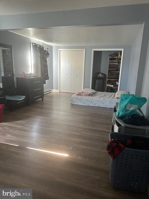 bedroom with hardwood / wood-style flooring and baseboard heating