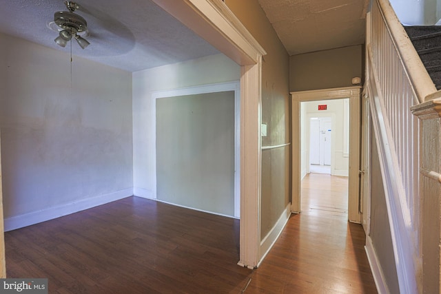 hall featuring dark wood-type flooring and a textured ceiling