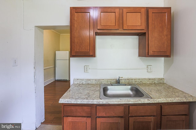 kitchen featuring hardwood / wood-style flooring, sink, and white refrigerator