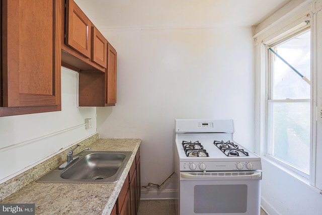 kitchen with white range with gas stovetop and sink