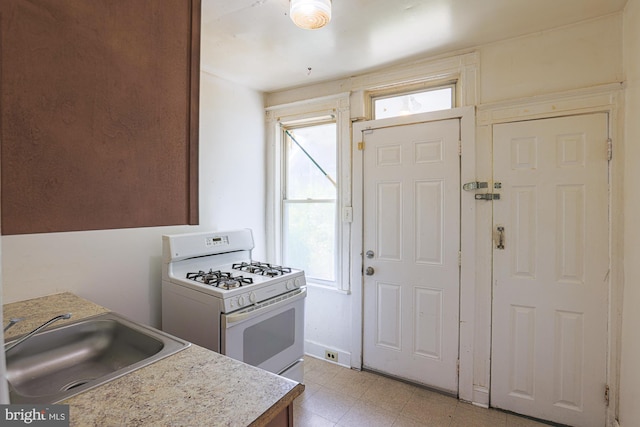 kitchen with white gas range and sink