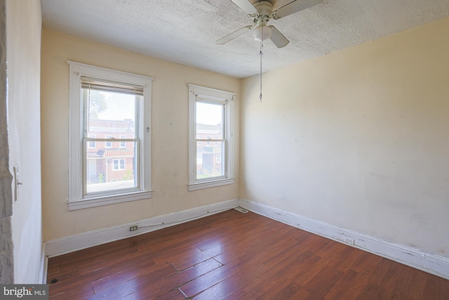 unfurnished room with dark wood-type flooring, ceiling fan, and a textured ceiling