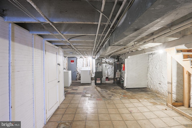 basement featuring washer / clothes dryer, heating unit, and water heater