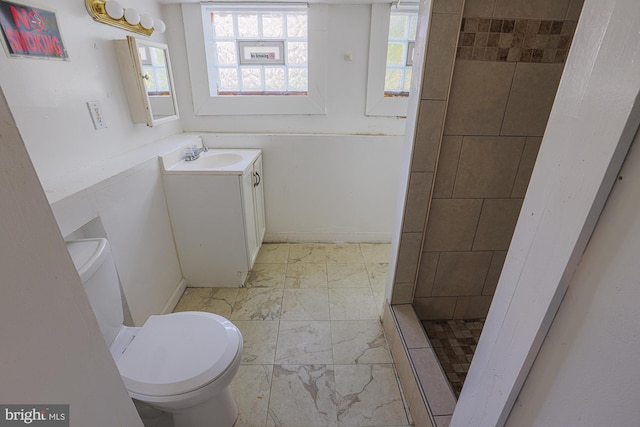 bathroom featuring vanity, toilet, and tiled shower