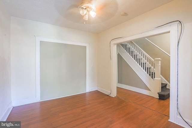 empty room with ceiling fan, wood-type flooring, and a textured ceiling