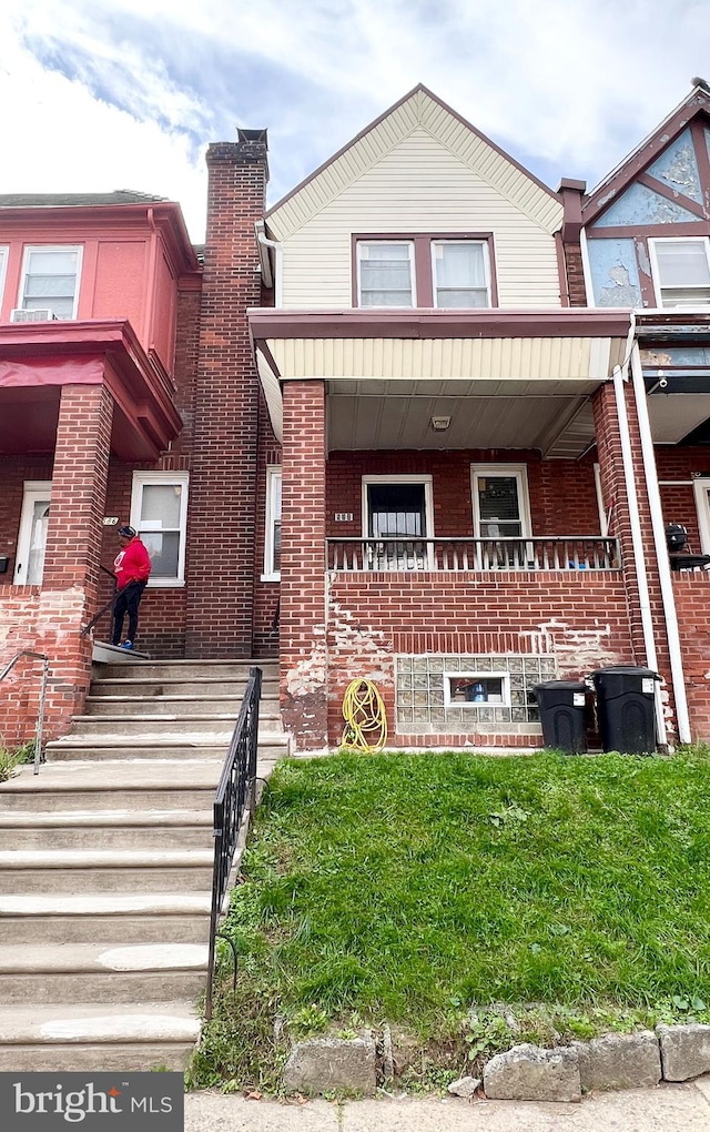 multi unit property with brick siding and a porch