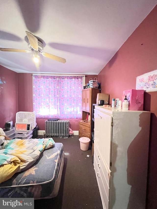 carpeted bedroom featuring radiator and ceiling fan