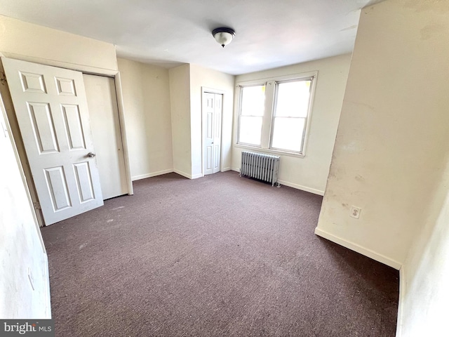 unfurnished bedroom with baseboards, carpet, and radiator