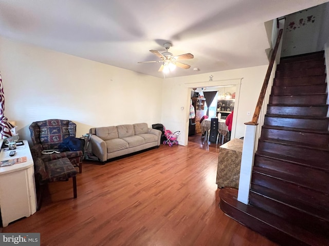 living room featuring stairs, ceiling fan, and wood finished floors