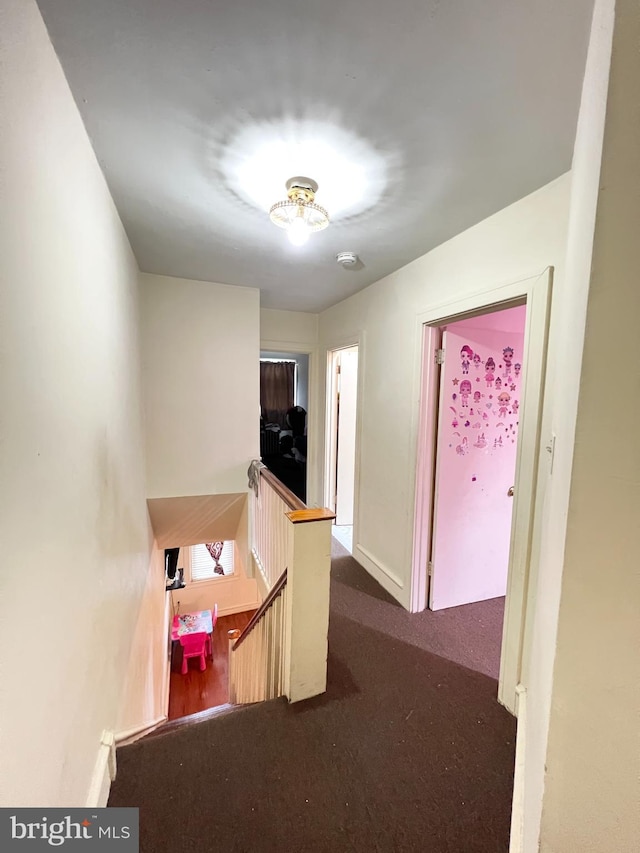 hall featuring carpet, an upstairs landing, and baseboards