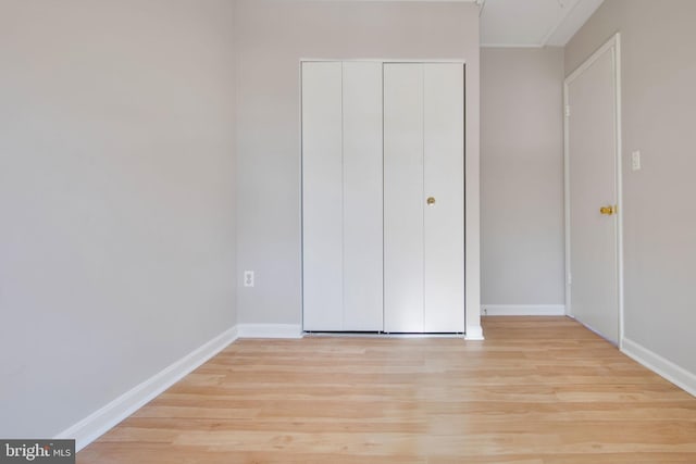 unfurnished bedroom with a closet and light hardwood / wood-style flooring