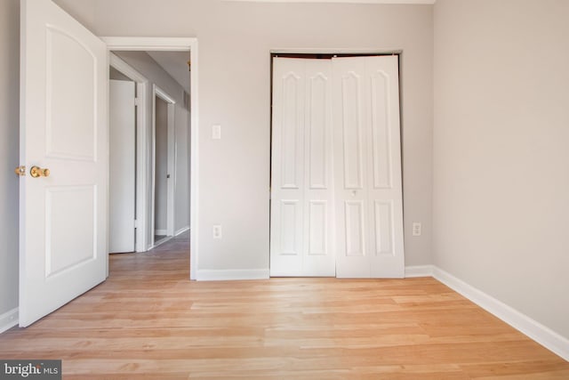 unfurnished bedroom with a closet and light wood-type flooring