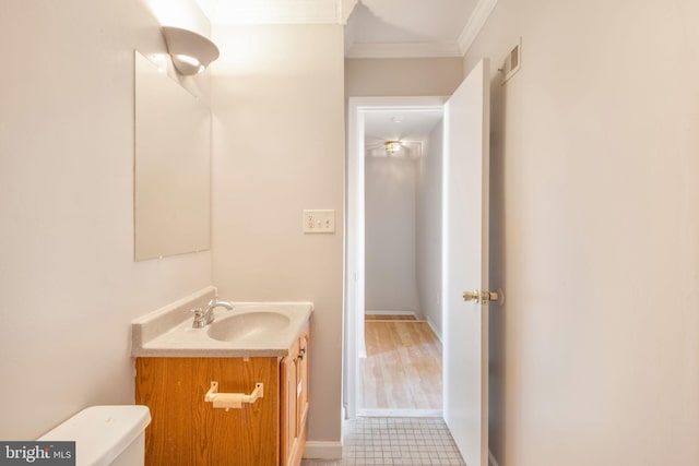 bathroom with toilet, hardwood / wood-style floors, vanity, and crown molding