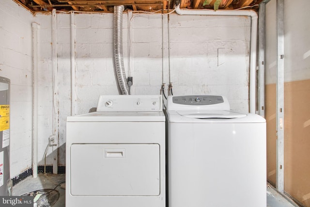 clothes washing area featuring electric water heater and washer and clothes dryer