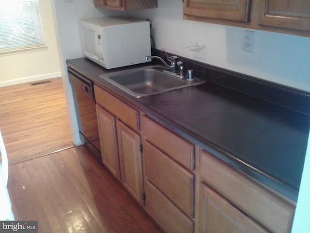 kitchen with dishwasher, light hardwood / wood-style flooring, and sink