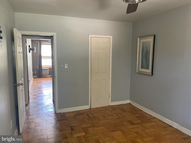 spare room with ceiling fan and dark parquet floors