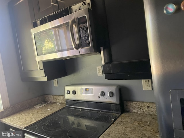 kitchen with range with electric stovetop and light stone counters