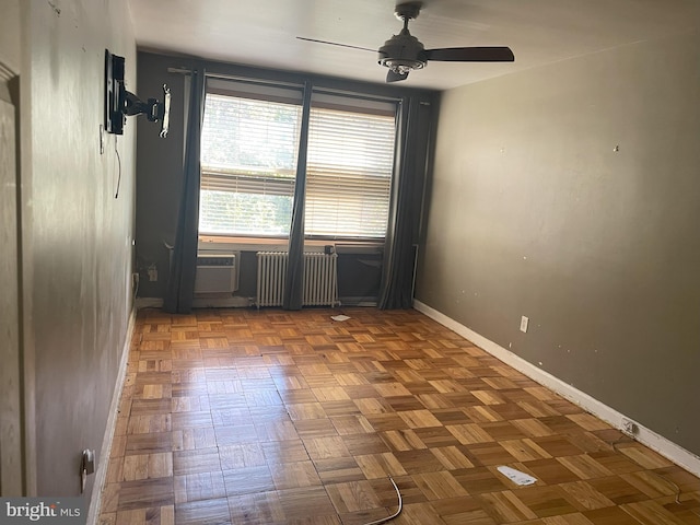 unfurnished room featuring ceiling fan, radiator heating unit, and light parquet flooring