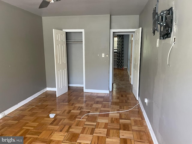 unfurnished bedroom with a closet and parquet flooring