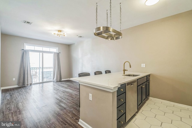 kitchen featuring light hardwood / wood-style flooring, sink, light stone counters, dishwasher, and kitchen peninsula