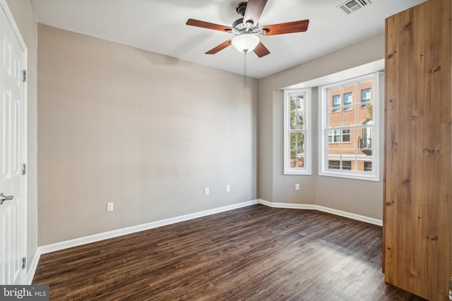 spare room featuring ceiling fan and dark wood-type flooring