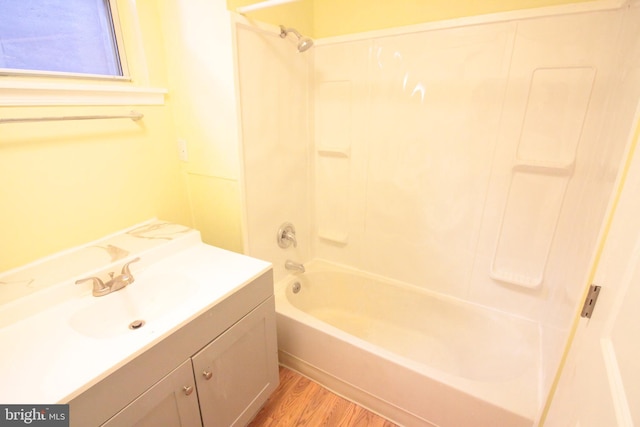 bathroom with wood-type flooring, washtub / shower combination, and vanity