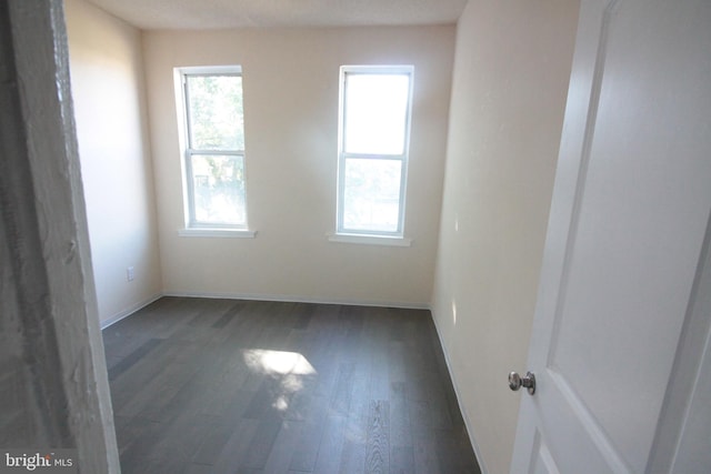 unfurnished room with dark hardwood / wood-style floors