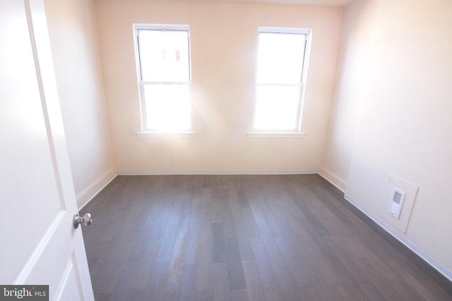 unfurnished room with plenty of natural light and dark hardwood / wood-style floors