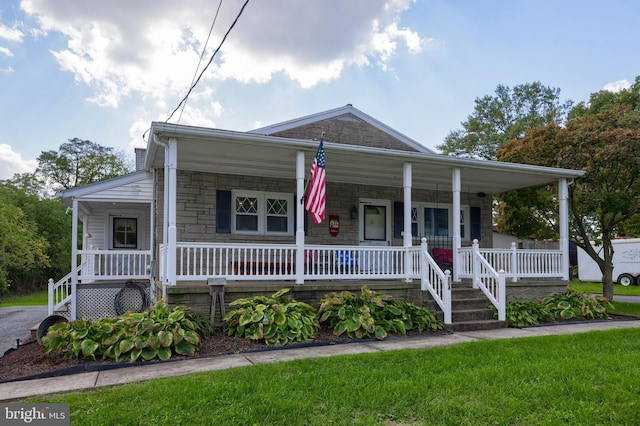 view of front of home featuring covered porch and a front yard