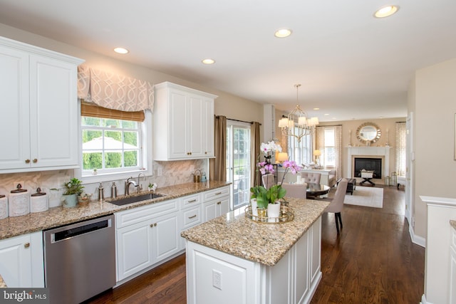 kitchen featuring pendant lighting, sink, stainless steel dishwasher, and white cabinetry