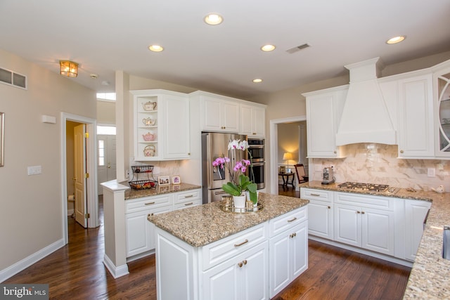 kitchen featuring custom exhaust hood, white cabinets, appliances with stainless steel finishes, and dark hardwood / wood-style flooring