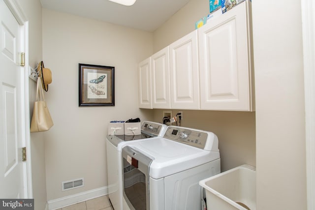 clothes washing area featuring separate washer and dryer, cabinets, sink, and light tile patterned flooring