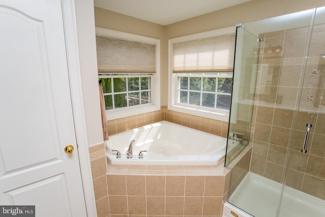 bathroom featuring shower with separate bathtub