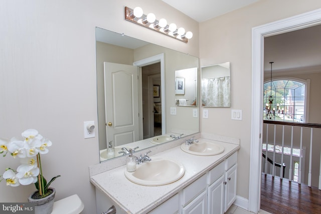 bathroom featuring a notable chandelier, hardwood / wood-style flooring, vanity, and toilet