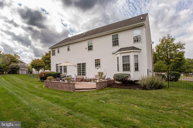 rear view of property featuring a lawn and a patio area