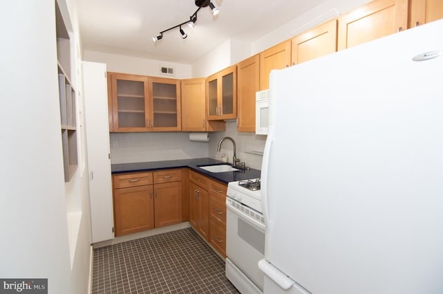 kitchen featuring decorative backsplash, white appliances, dark tile patterned flooring, and sink