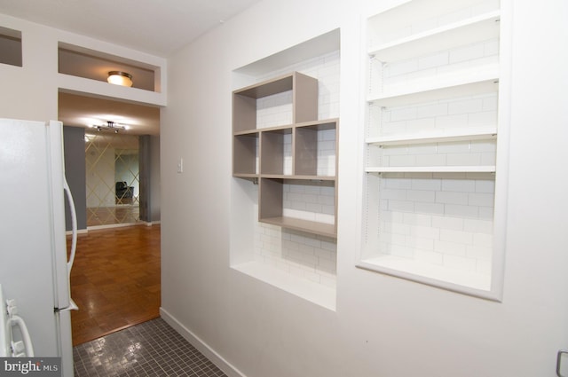 hall featuring dark tile patterned flooring