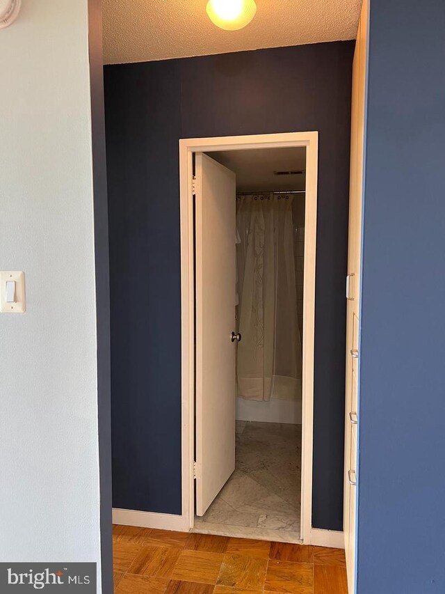 hallway with a textured ceiling