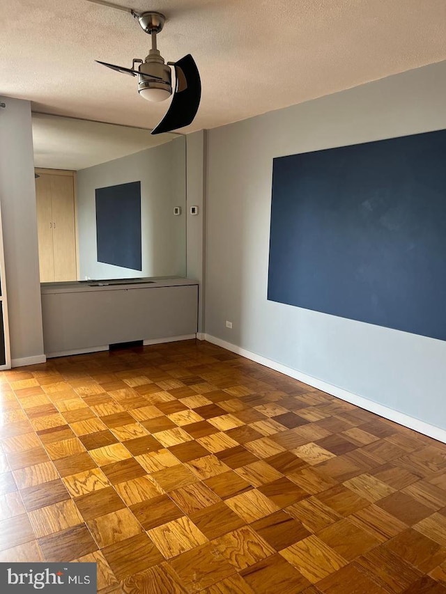 spare room featuring ceiling fan and a textured ceiling