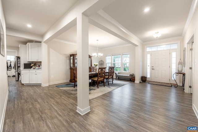 foyer featuring ornamental molding, dark hardwood / wood-style floors, and a chandelier