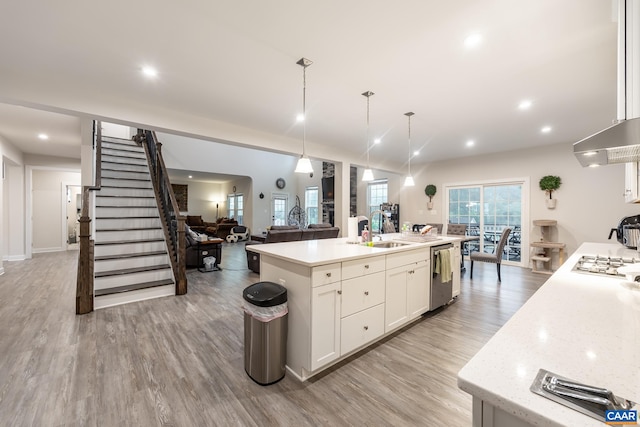 kitchen with appliances with stainless steel finishes, sink, an island with sink, and decorative light fixtures