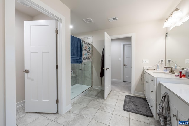 bathroom featuring vanity, tile patterned flooring, and a shower with door