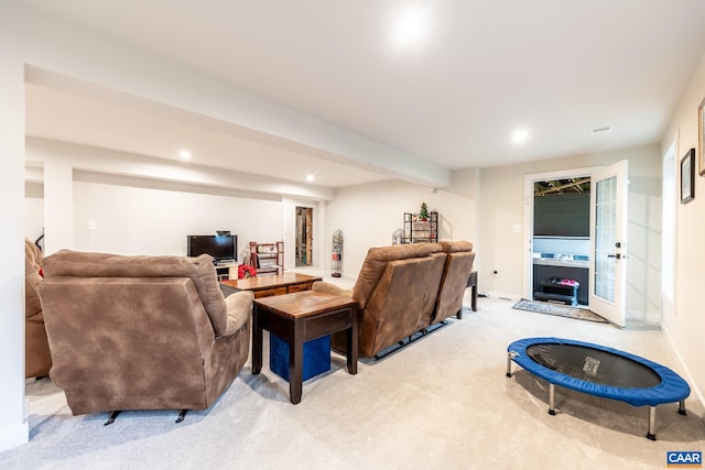 carpeted living room with beamed ceiling