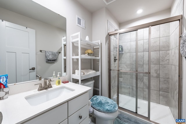 bathroom with an enclosed shower, vanity, and toilet