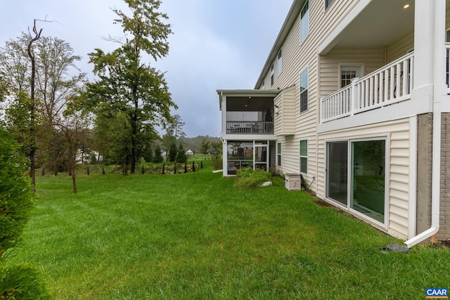 view of yard with a balcony and a sunroom