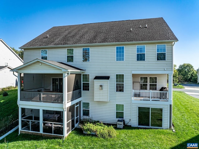 back of property featuring a lawn, a sunroom, and a balcony