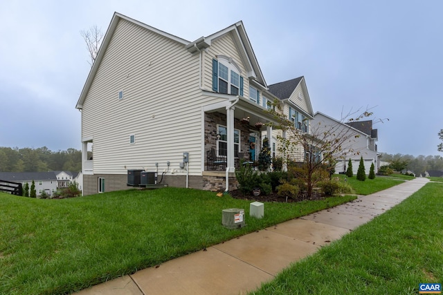 view of side of property with a lawn and cooling unit