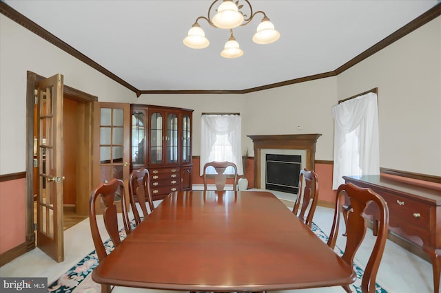 dining space featuring crown molding, a notable chandelier, and lofted ceiling